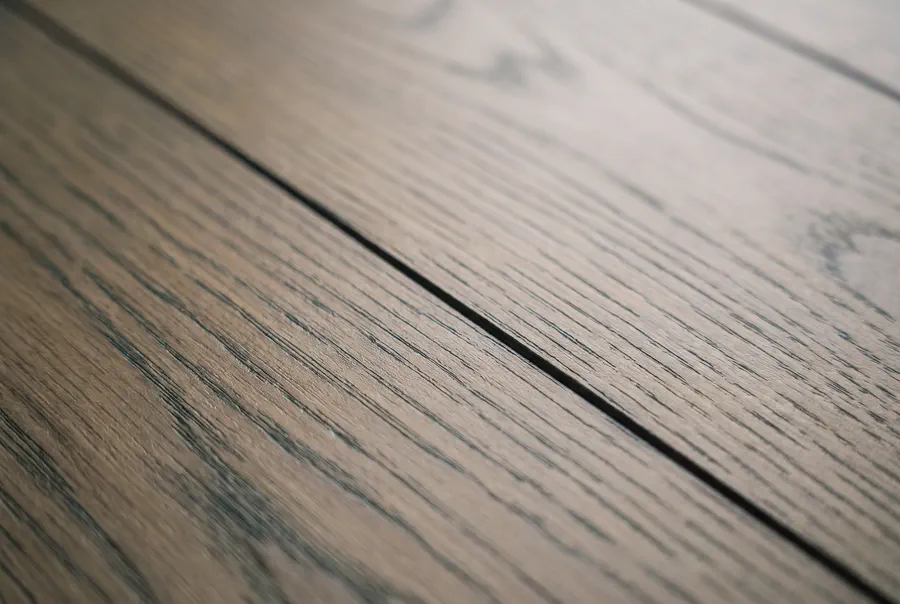 Oberfläche einer Laminatdiele mit V-Fuge im Streiflicht